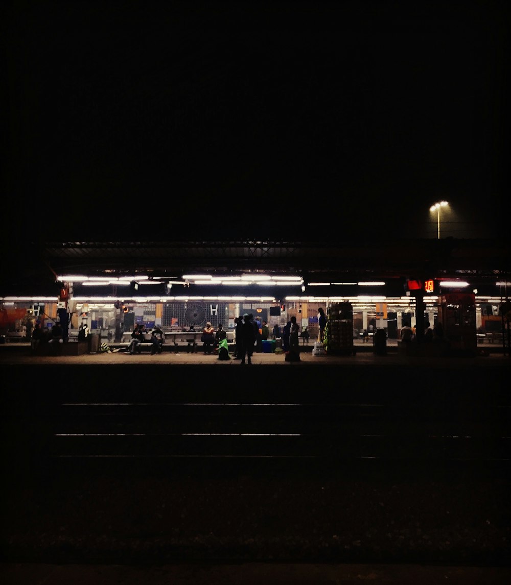 people walking on sidewalk during night time