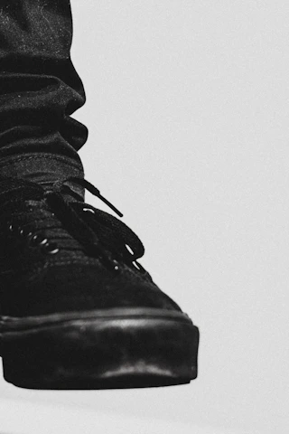 A close-up of a sleek, modern sneaker on a minimalist black-and-white background highlighting its craftsmanship.