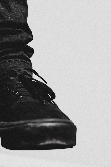 Close-up of a sleek black Nike Dunk Low sneaker with subtle neon accents on a dark background.
