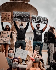 group of people holding white and black banner