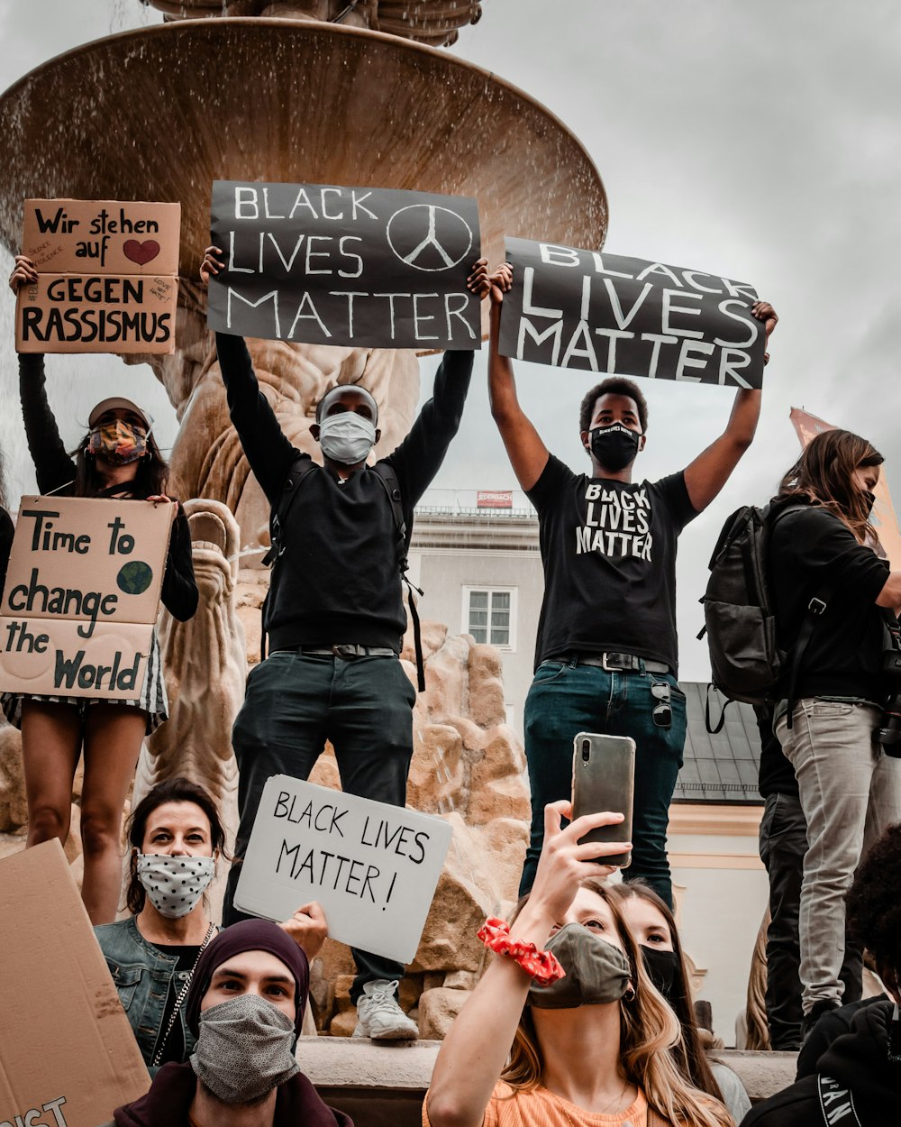 group of people holding white and black banner