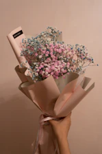 A delicate hand-tied bouquet with soft pastel flowers in minimalist wrapping.
