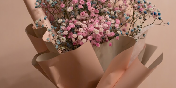 pink and white flowers in brown paper bag