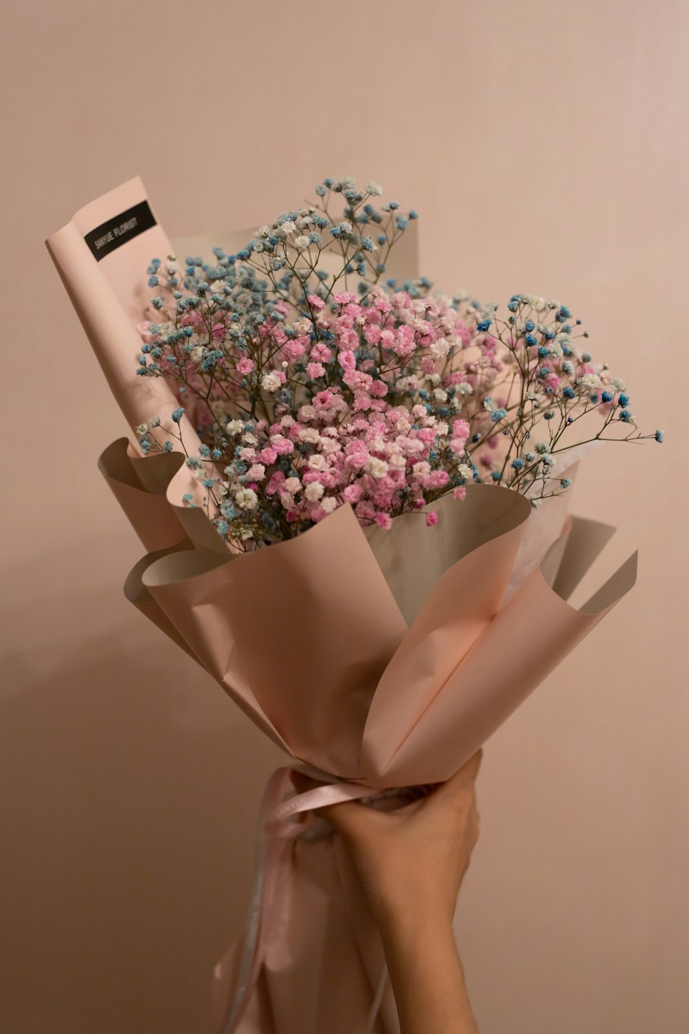 pink and white flowers in brown paper bag