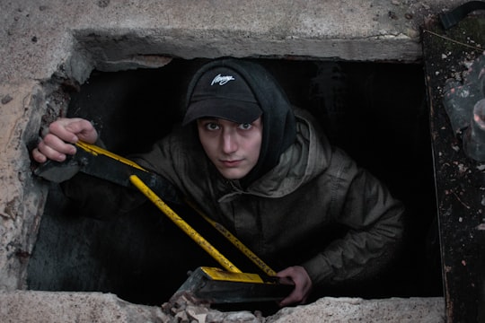 man in black hoodie and black cap holding yellow bar in Besançon France