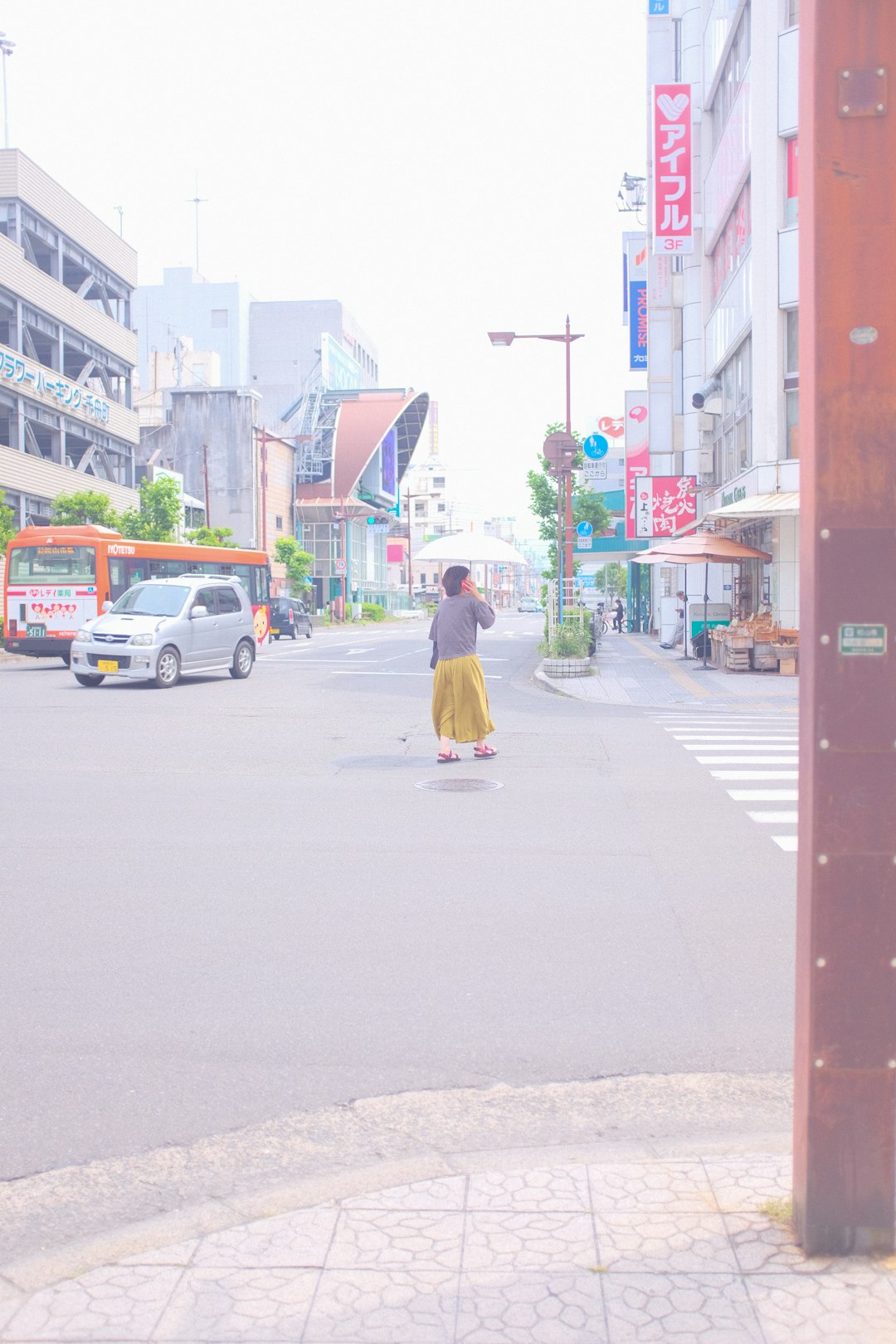 woman in pink long sleeve shirt and blue denim jeans walking on sidewalk during daytime