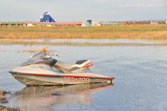 Technician performing a swift jetski engine repair by the lakeside.