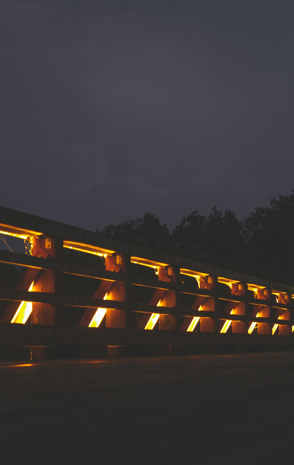 brown wooden fence near trees during night time