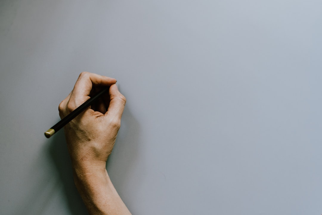 person holding black pen on white table