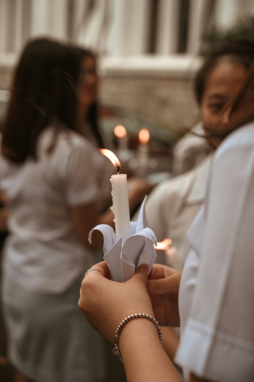 woman in white long sleeve shirt holding white plastic toy