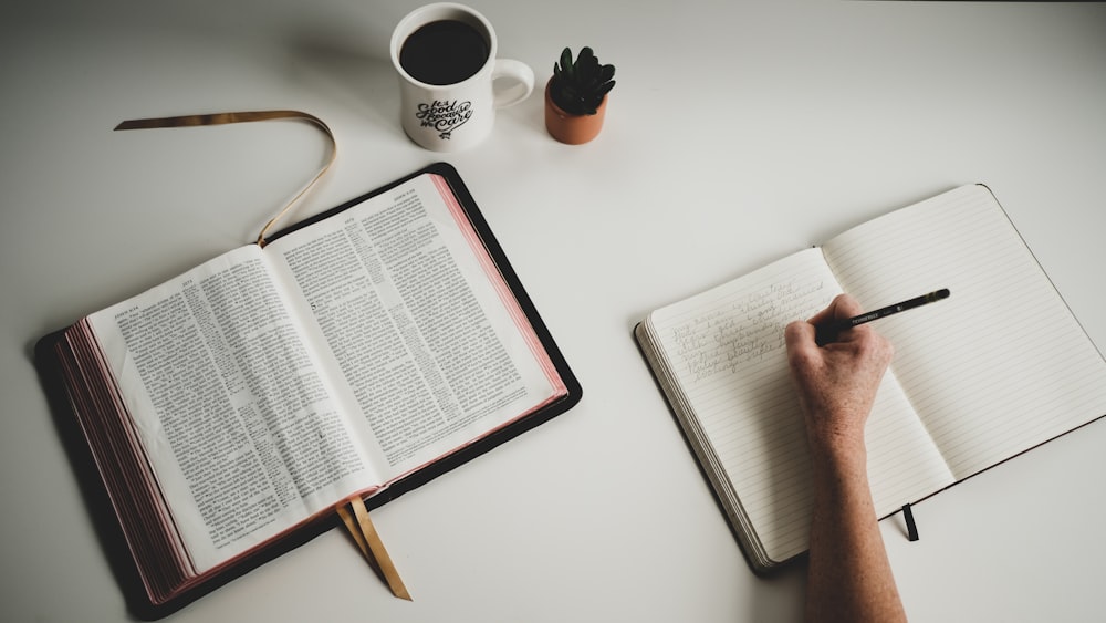 person holding white book page on white table