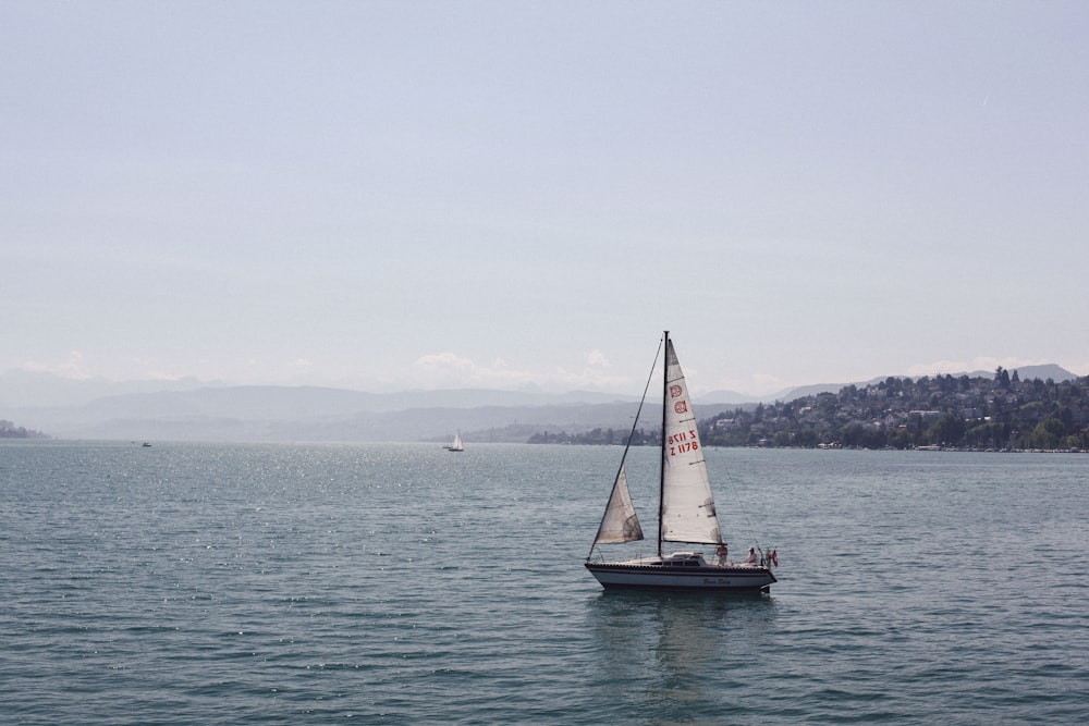 sailboat on sea under white sky during daytime