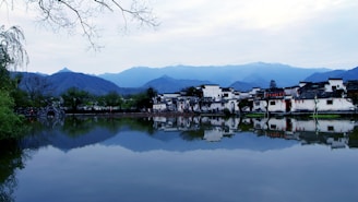 A serene landscape of a traditional Batak village with mountains in the background.