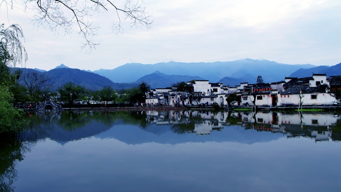 A serene landscape of a traditional Batak village with mountains in the background.