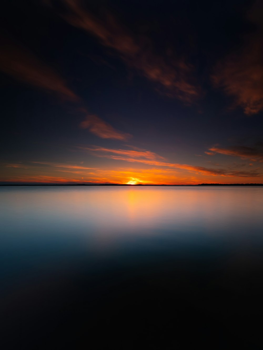 body of water under blue sky during sunset