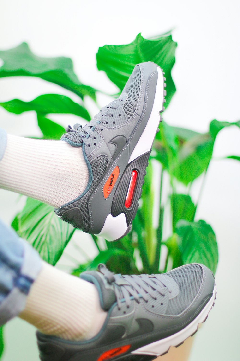 Persona con zapatos deportivos Nike grises y blancos