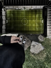 person in black pants and black and white sneakers standing on gray stone