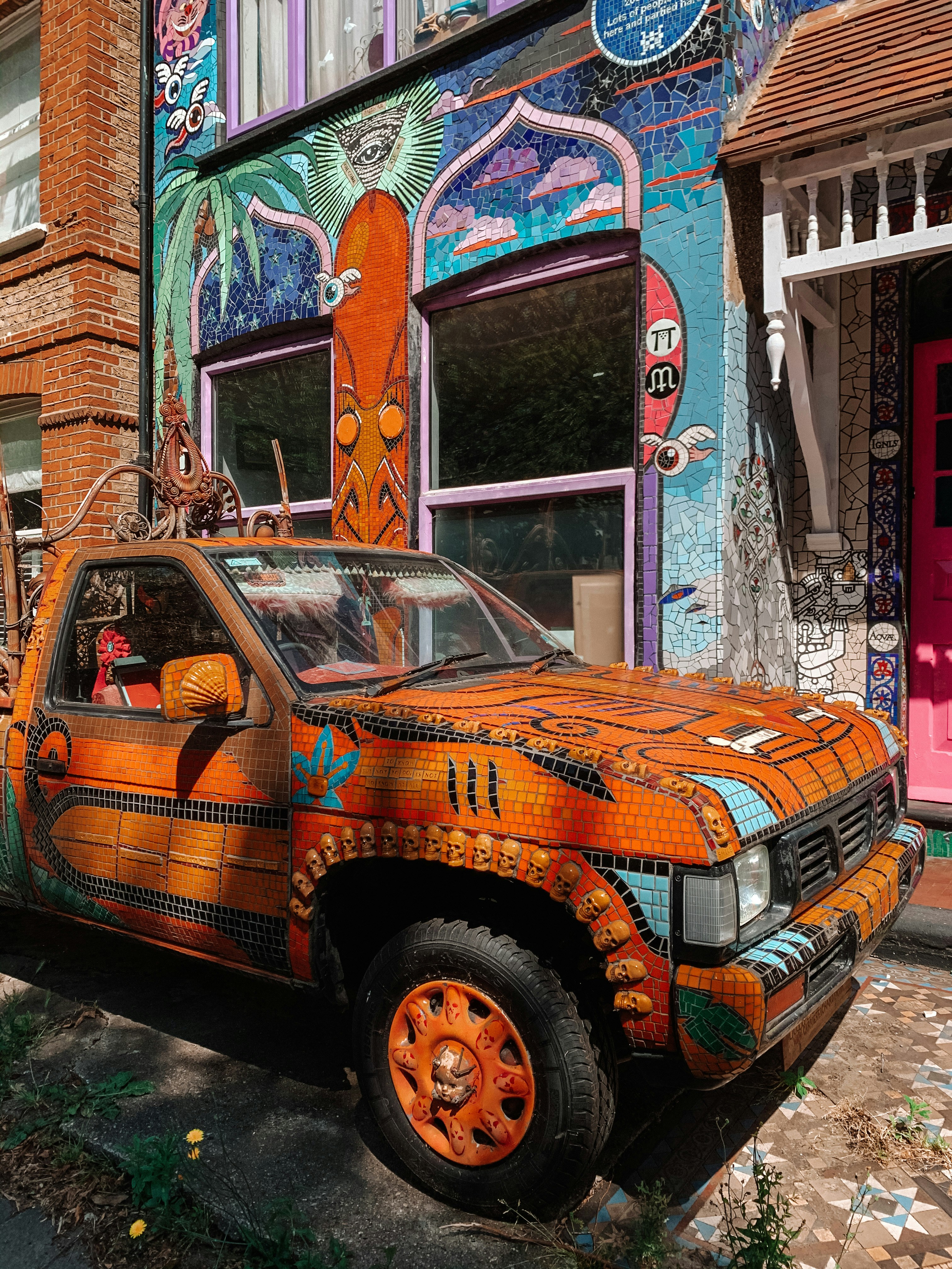 brown and white car parked beside brown concrete building during daytime