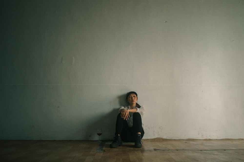 woman in black long sleeve shirt sitting on brown wooden floor