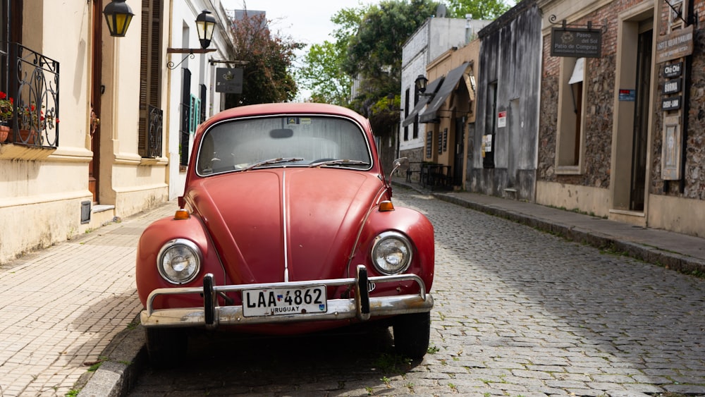 red volkswagen beetle parked on sidewalk during daytime