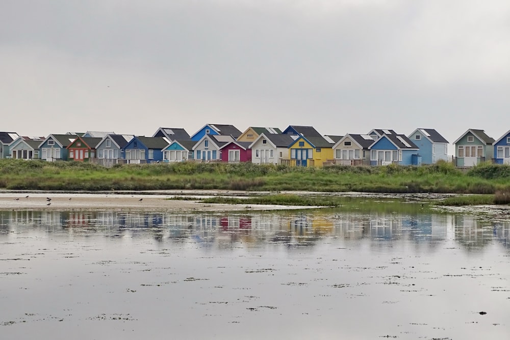 Maison blanche et verte près d’un plan d’eau pendant la journée