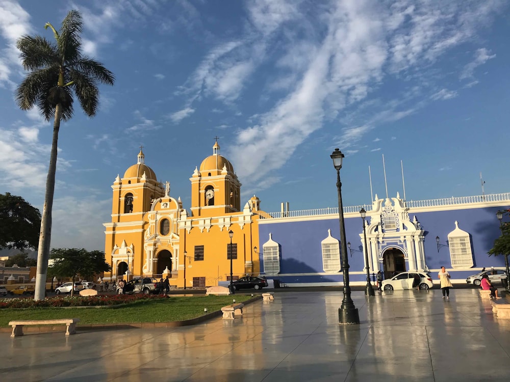 Edificio de hormigón amarillo y blanco bajo el cielo azul durante el día