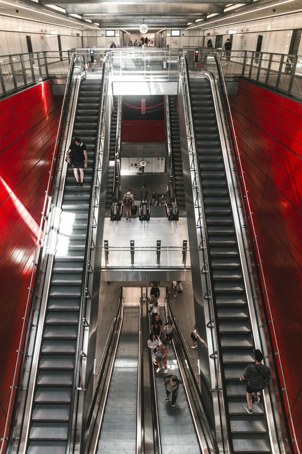 people walking on red and gray escalator