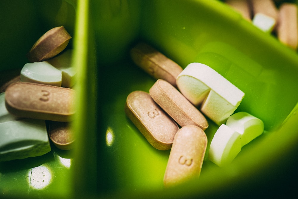 white medication pill on green plastic container