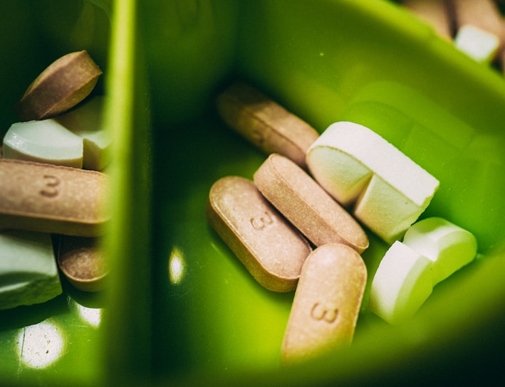 white medication pill on green plastic container