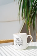 white and black ceramic mug on white wooden table