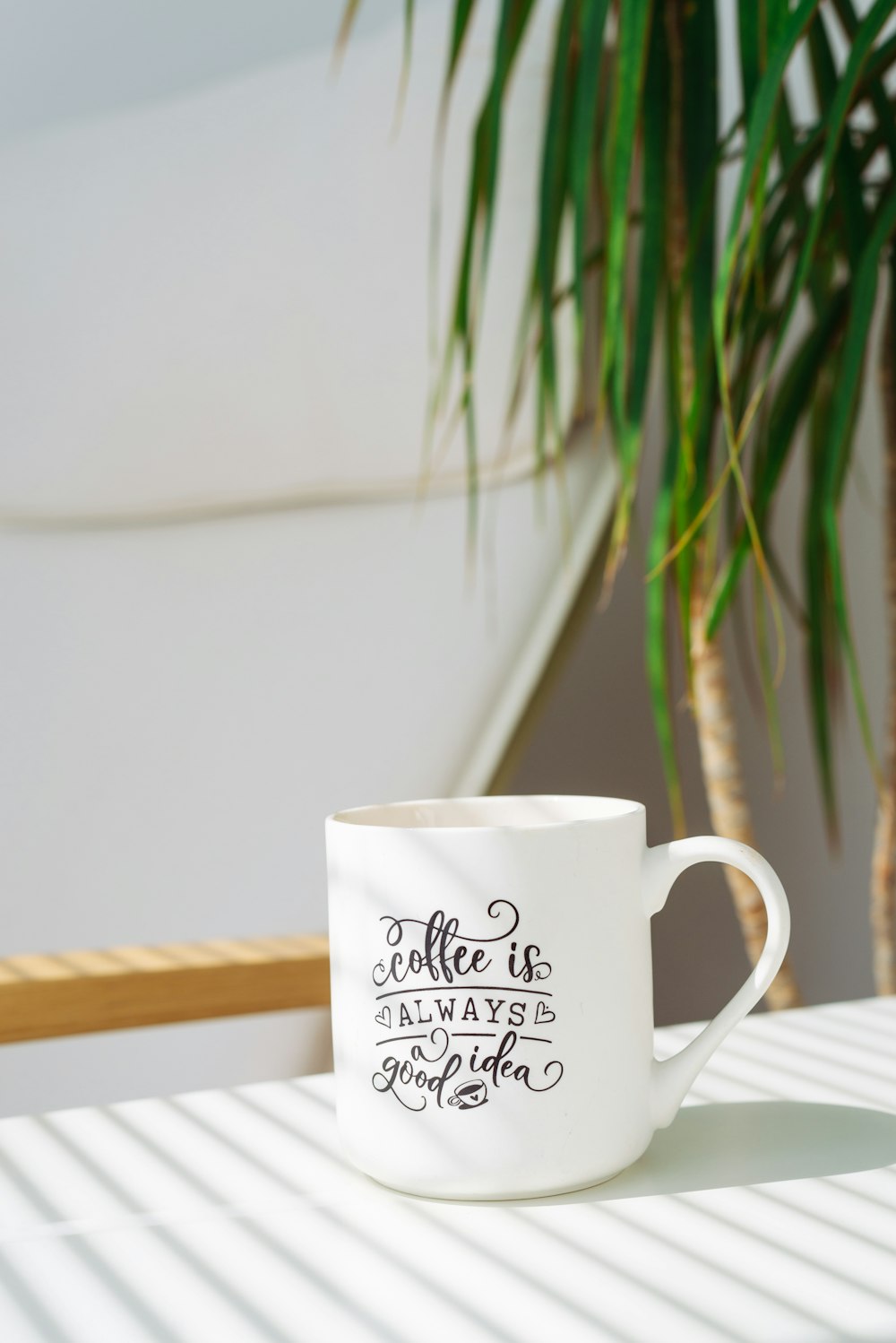 white and black ceramic mug on white wooden table