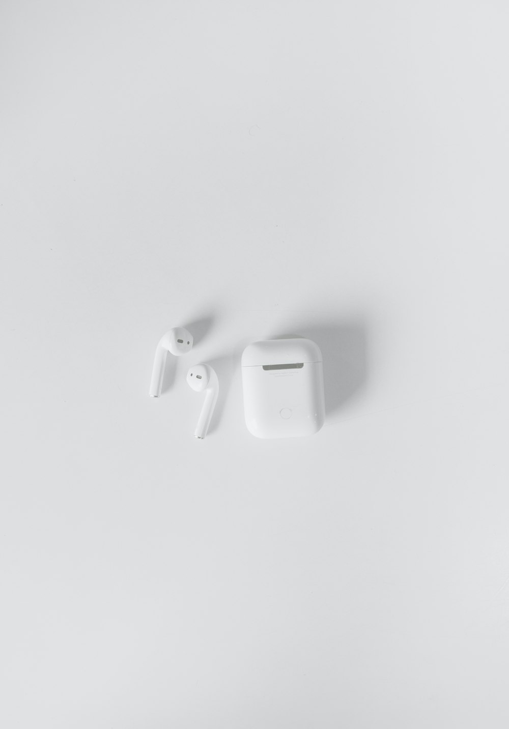white apple earpods on white surface