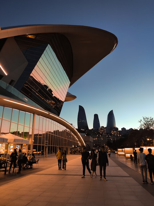 people walking on park near building during night time in Dənizkənarı Milli Park Azerbaijan