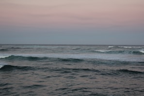 A calm ocean scene with gentle waves under a twilight sky
