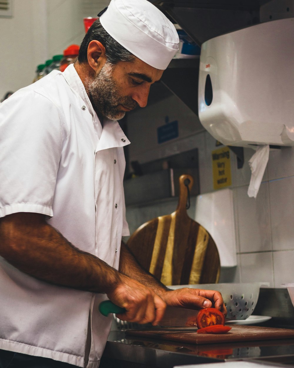 man in white chef uniform holding brown wooden ladle