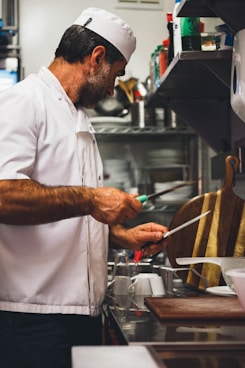 man in white chef uniform holding chopsticks