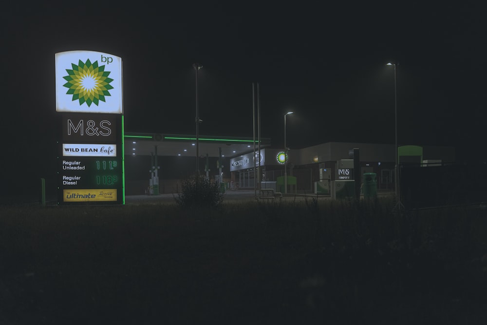 a gas station sign lit up at night