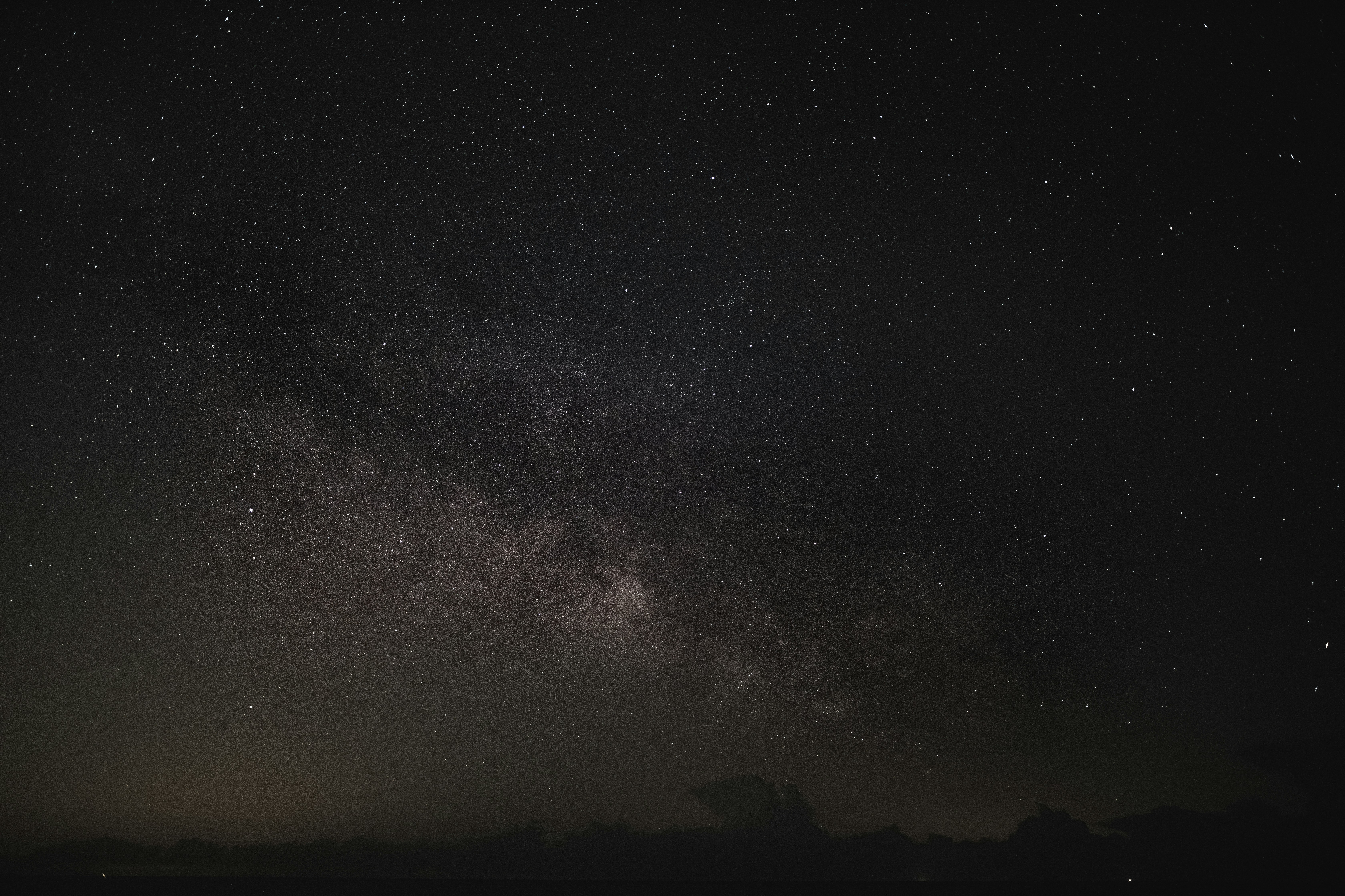 silhouette of mountain under starry night