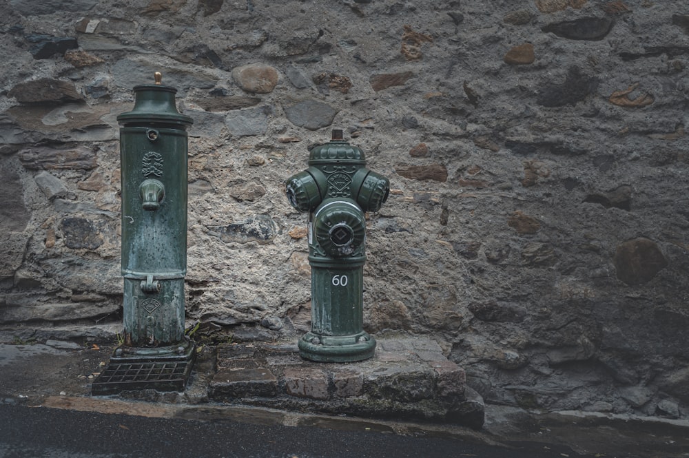 Borne-fontaine en acier noir sur mur de béton brun