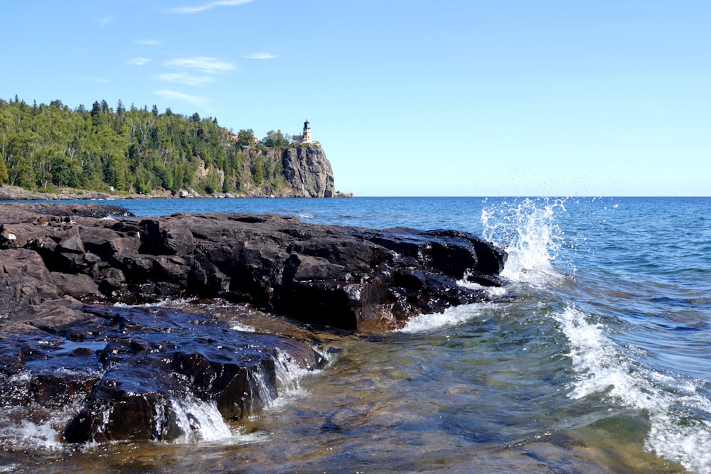 rocky mountain beside body of water during daytime