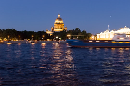 white and brown dome building near body of water during night time in State Hermitage Museum Russia