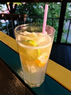 Refreshing fruit juice served in a tall glass with ice cubes and a straw.