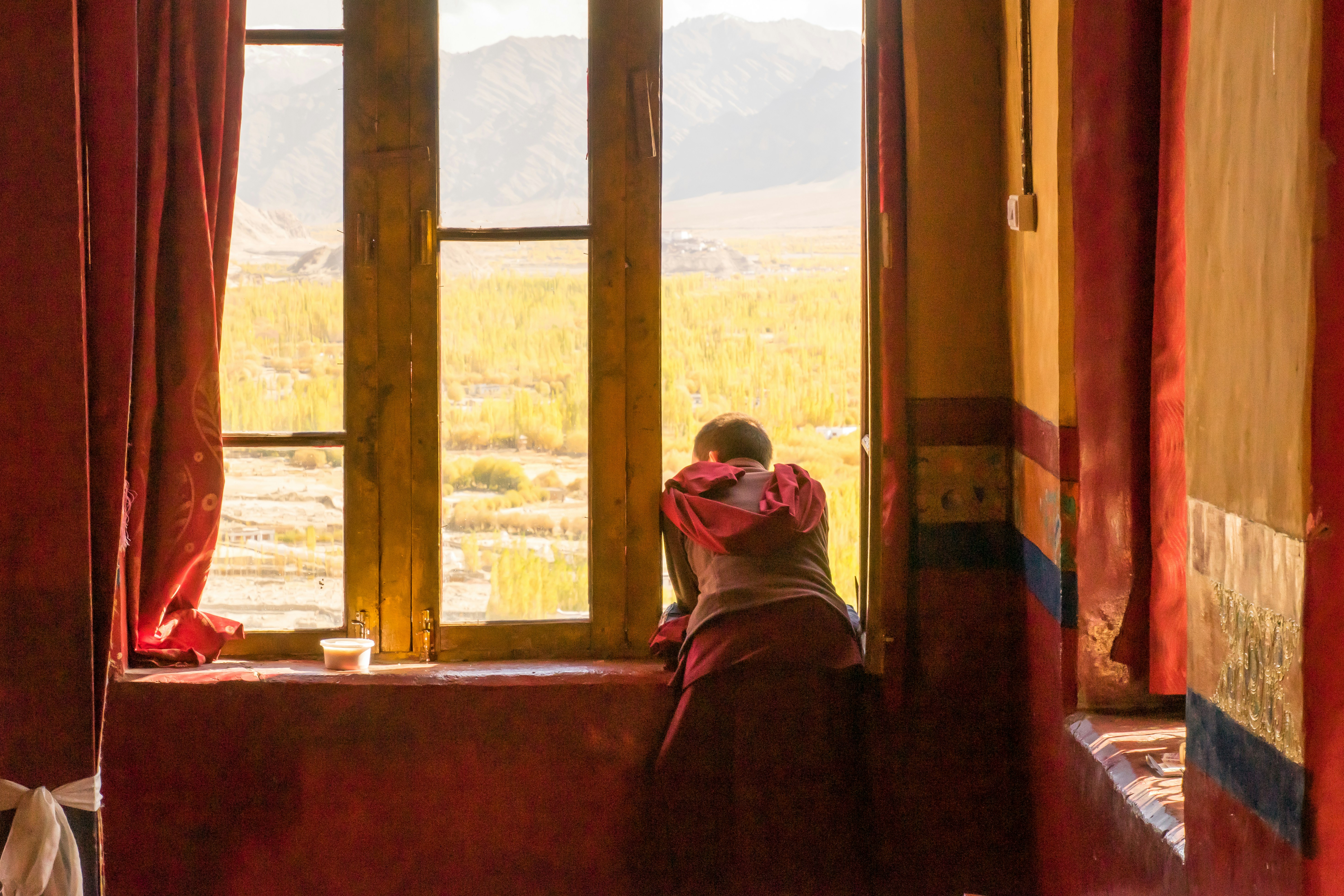 Students studying diligently in a classroom with snow visible outside the window in Ladakh.