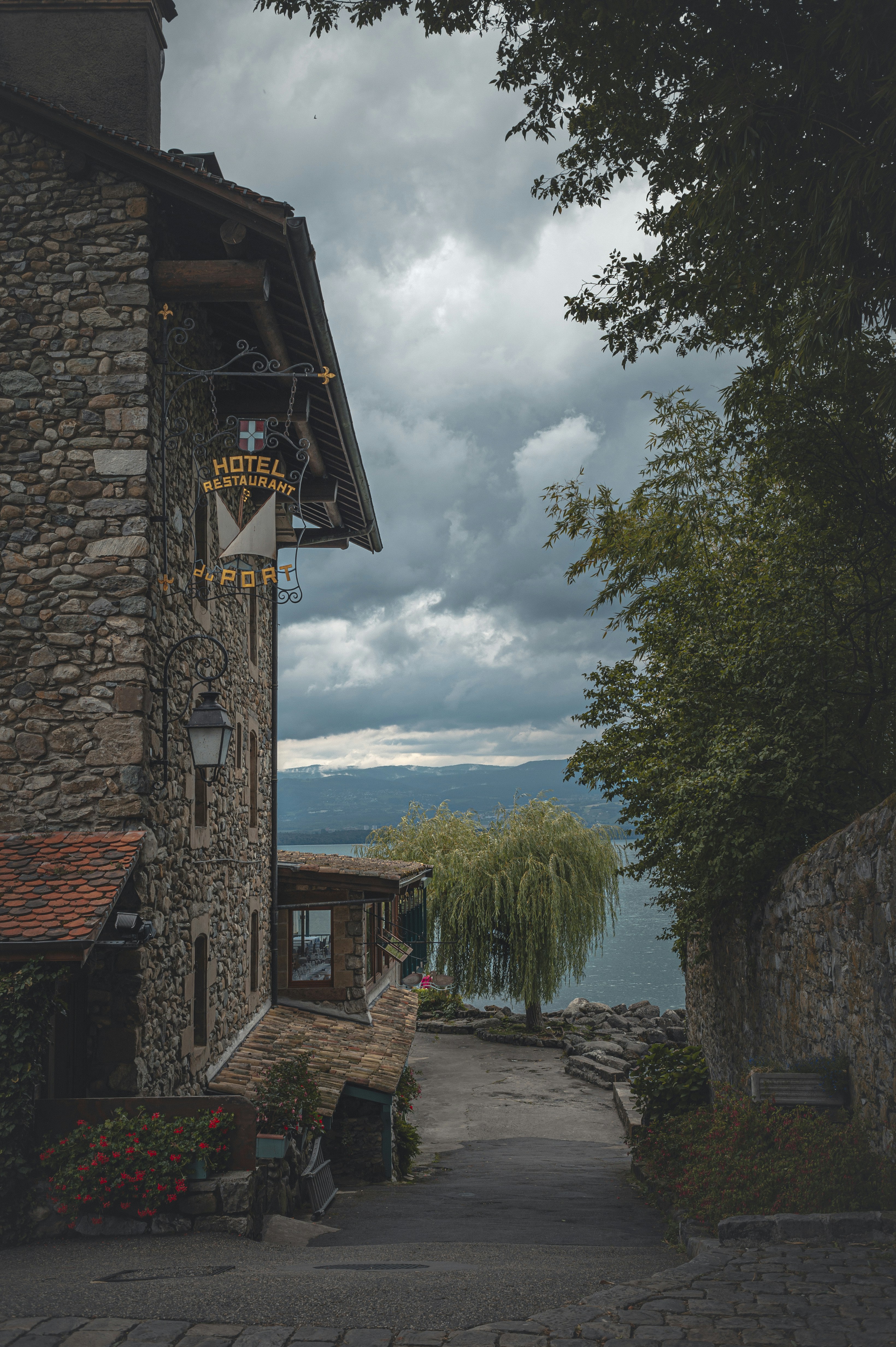 brown brick building near green trees and body of water during daytime