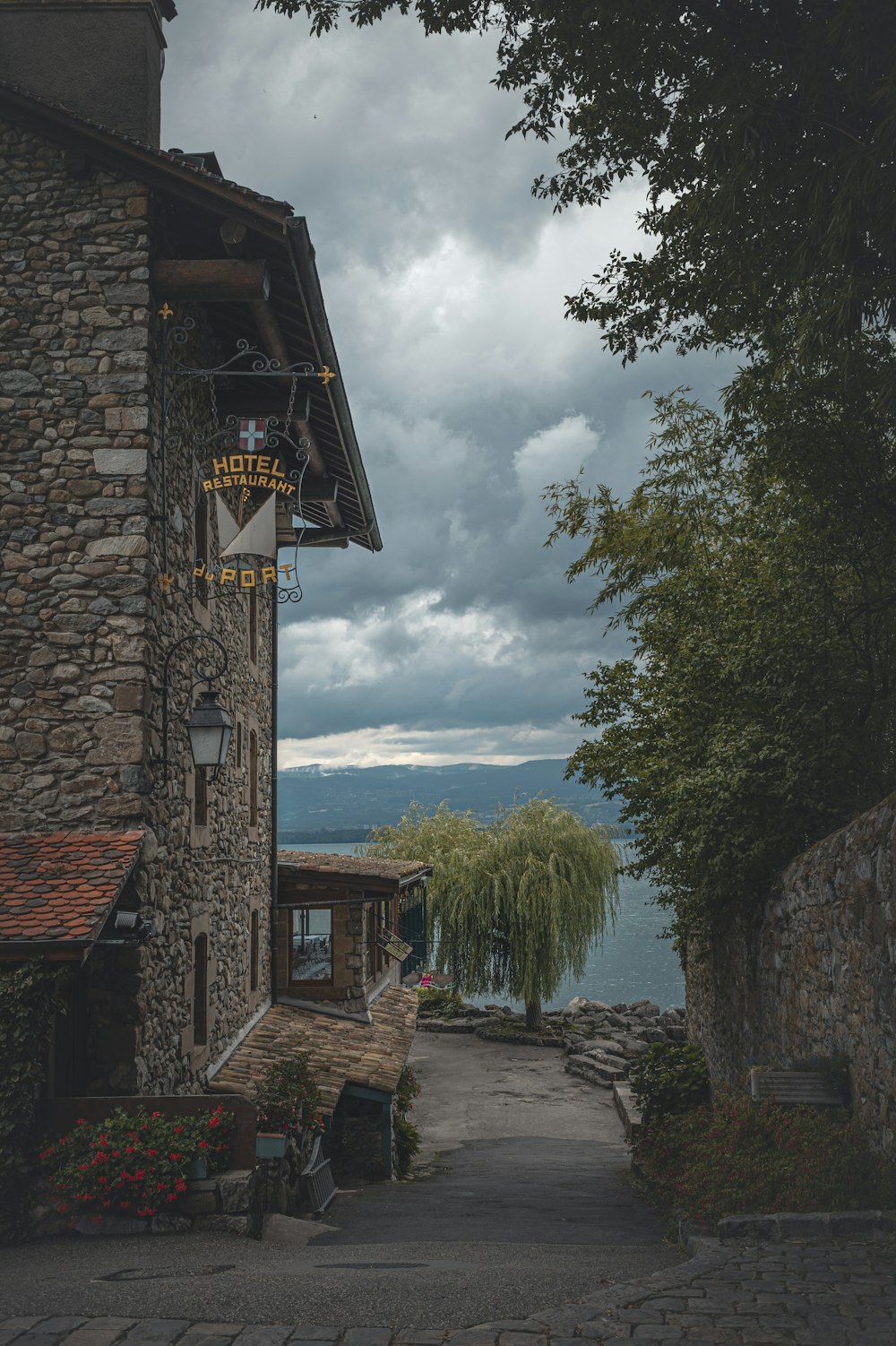 brown brick building near green trees and body of water during daytime