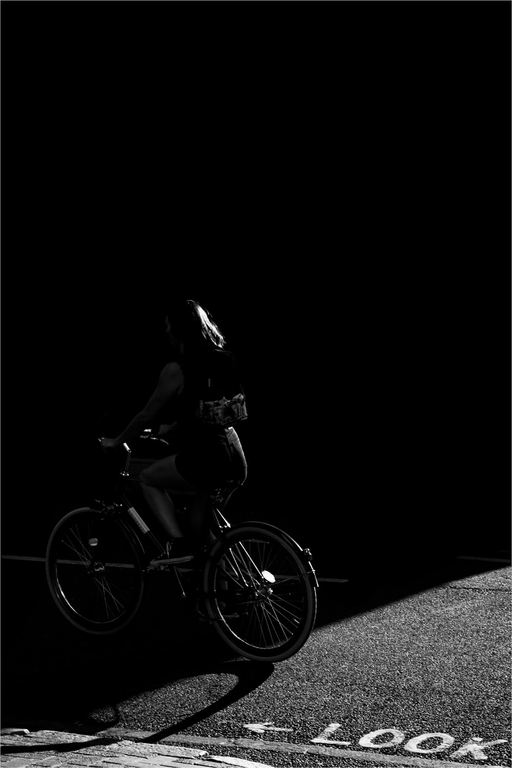 grayscale photo of woman riding bicycle