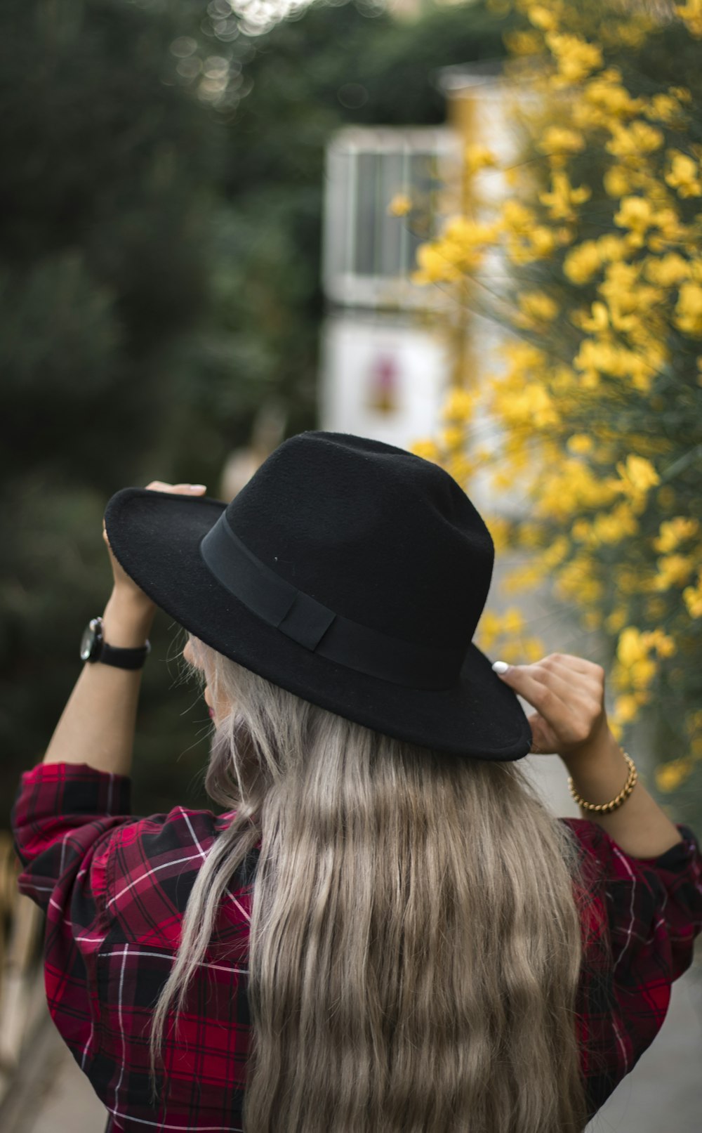 woman in black fedora hat and red plaid shirt