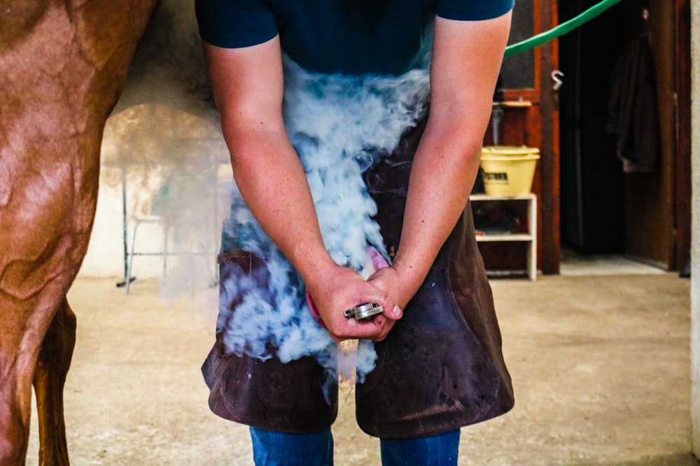 man in blue t-shirt holding brown leather bag