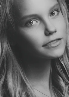 A close-up portrait of a quinceañera in a softly lit studio, capturing her serene expression.
