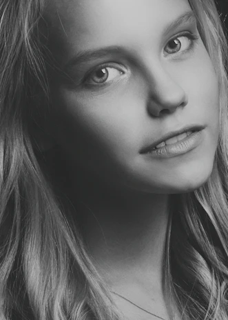 A close-up portrait of a quinceañera in a softly lit studio, capturing her serene expression.